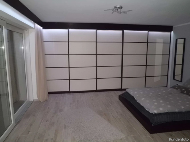 weiße Glasschiebetüren mit schwarzen Rahmen machen dieses Schlafzimmer einmalig
