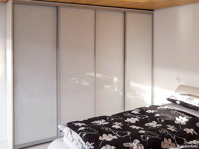 großzügiger, raumhoher und zeitloser Schlafzimmerschrank mit attraktiven weißen Glastüren